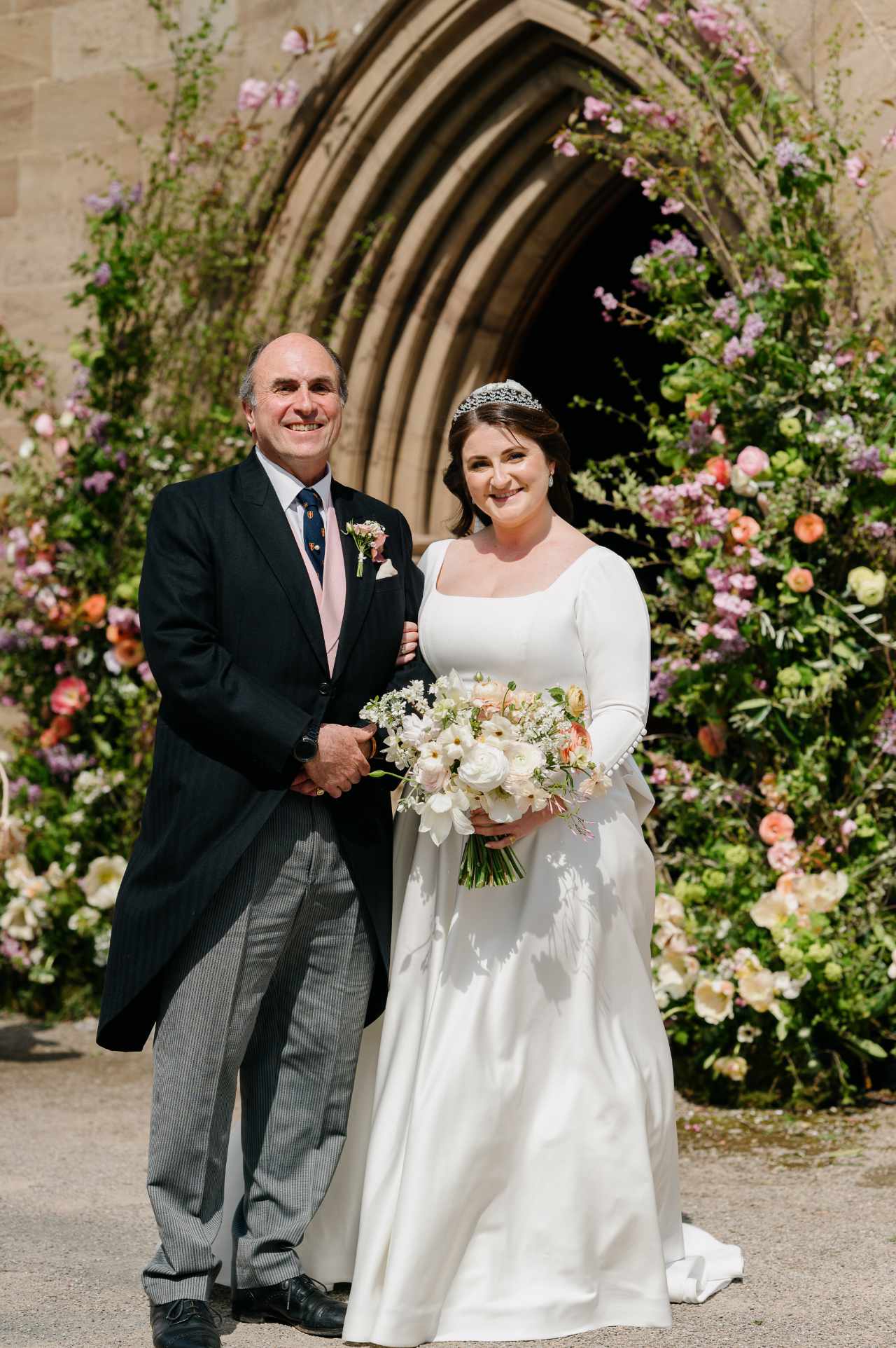Bride and father in church floral archway