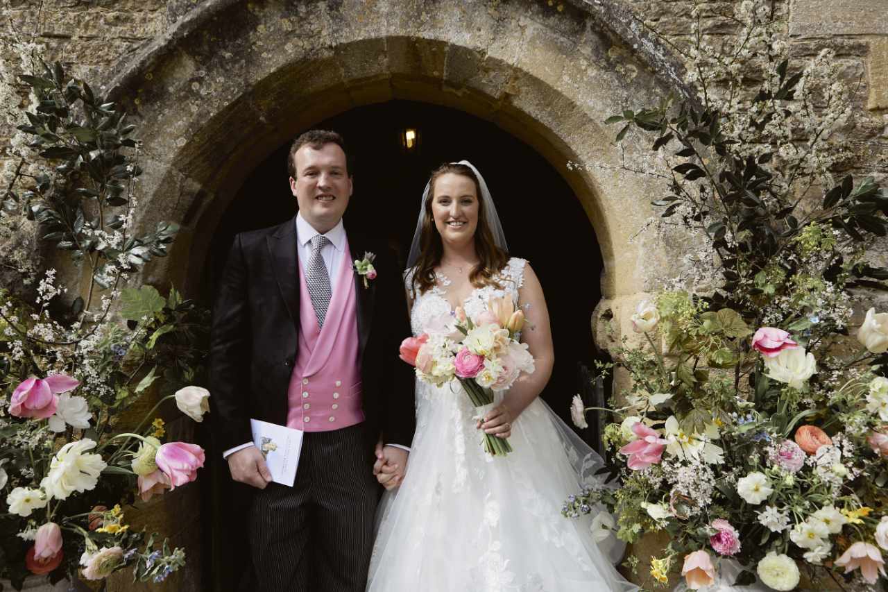 Happy bride and groom surrounded by flowers on their wedding day