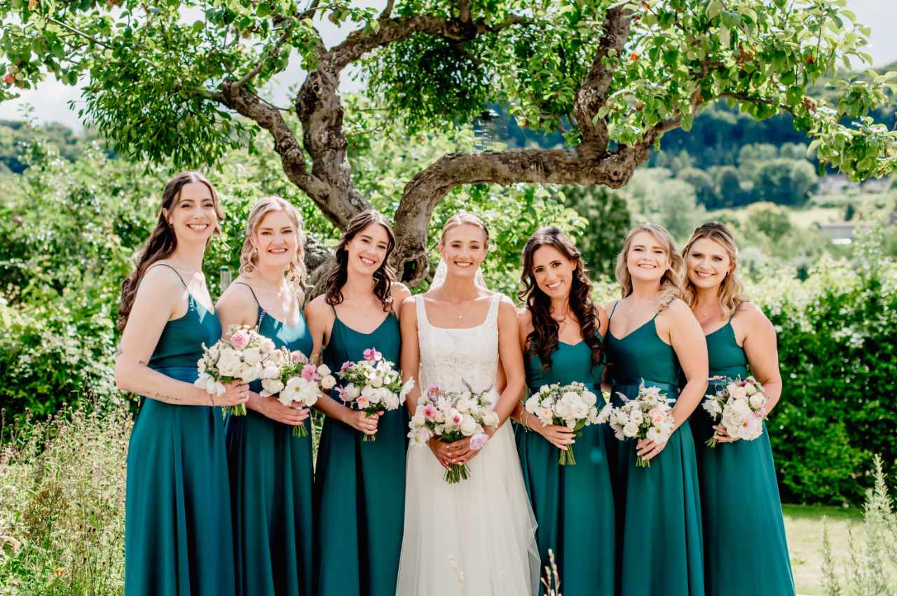 Bride with bridesmaids in green with wedding flowers