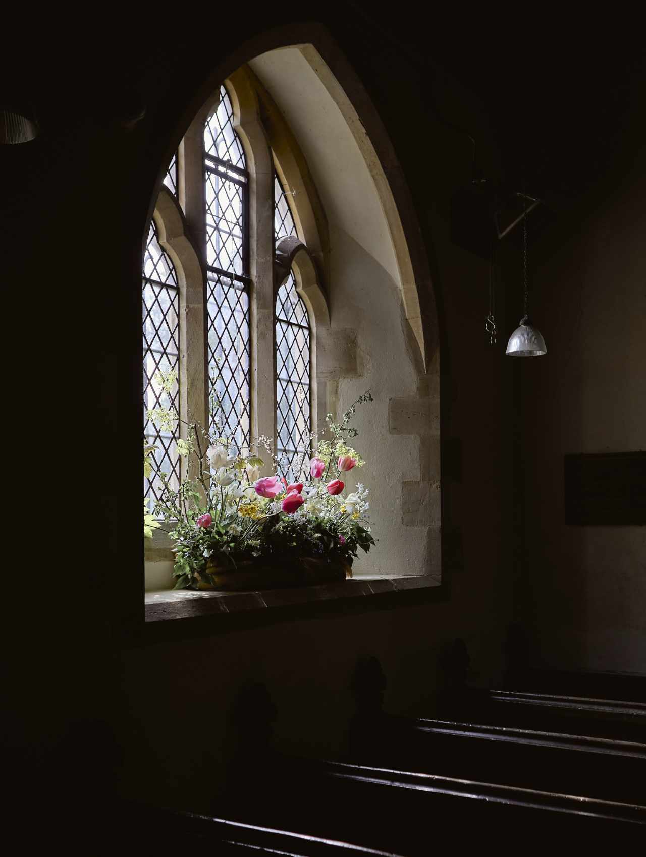 Church window with wedding flowers illuminated