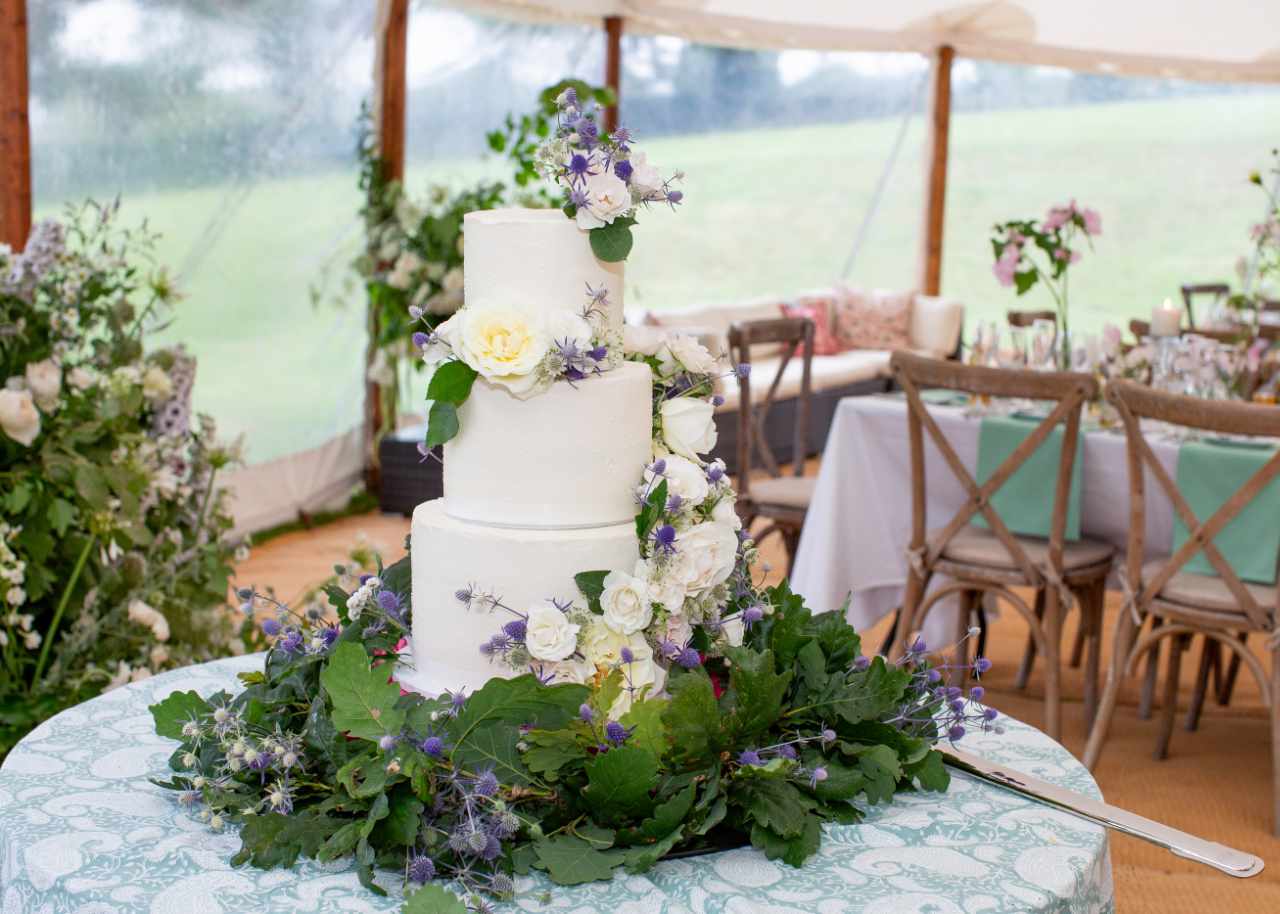 Stunning wedding cake surrounded by flowers and greenery