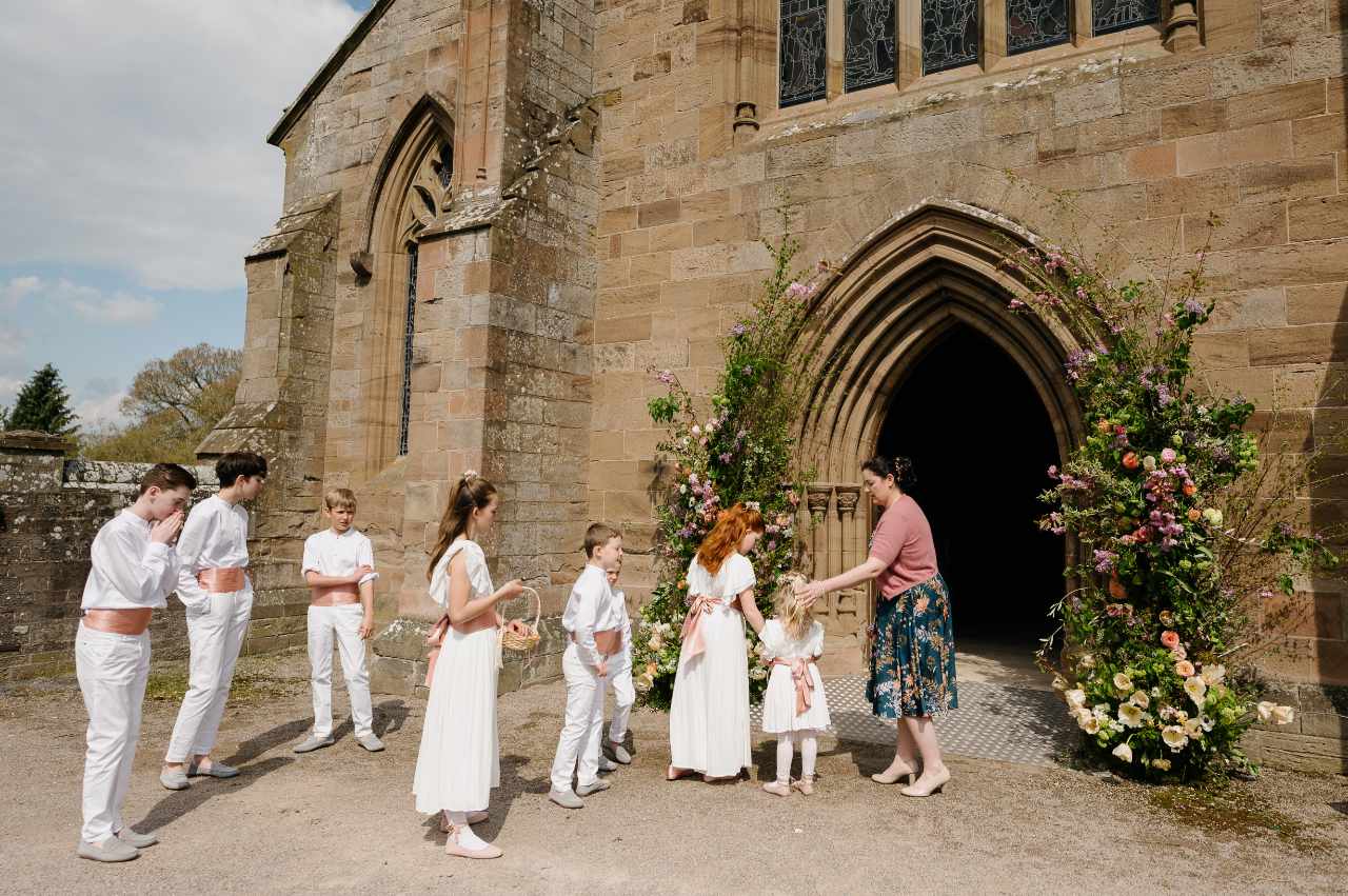 Wedding party outside church with floral door design